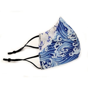 May include: A blue and white face mask with a wave pattern. The mask has black adjustable straps.