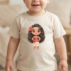 May include: A beige toddler t-shirt featuring a cartoon illustration of a Polynesian girl with long black hair, a red flower, and a red and white outfit. The word "NATURAL" is printed in black at the bottom of the shirt.