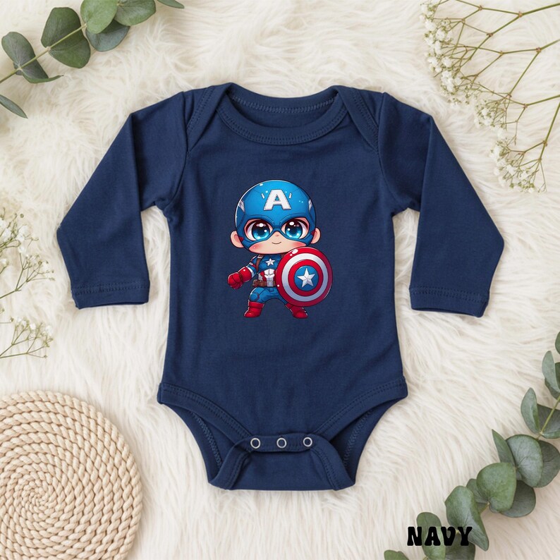 Op de afbeelding: Marineblauwe babybody met lange mouwen. De body heeft een cartoonillustratie van Captain America met een schild. Het ontwerp bevat de letter "A" op de helm van het personage. Het woord "NAVY" staat onderaan gedrukt.