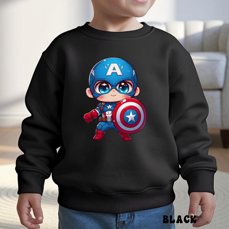 Op de afbeelding: Zwarte sweatshirt met een cartoon Captain America-ontwerp. Het personage draagt een blauwe helm met een witte "A", een blauw en rood pak en houdt een rood, wit en blauw schild vast. Het woord "BLACK" staat onderaan het kledingstuk.