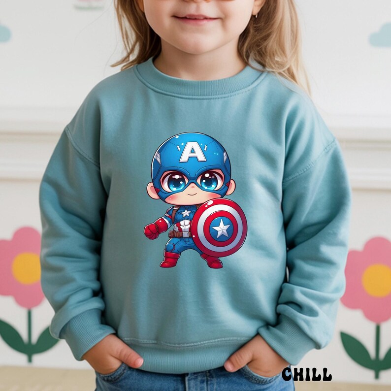 Op de afbeelding: Een lichtblauwe sweatshirt met een cartoon Captain America-afbeelding. De illustratie toont Captain America met zijn schild. Het woord "CHILL" staat rechtsonder op de sweatshirt.
