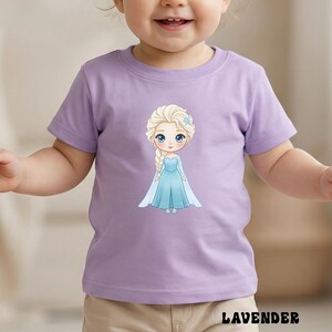 Puede incluir: Una camiseta lavanda con una ilustraci&oacute;n de dibujos animados de una princesa con un vestido azul y una trenza rubia. La palabra "LAVENDER" est&aacute; impresa en negro en la parte inferior de la camiseta.