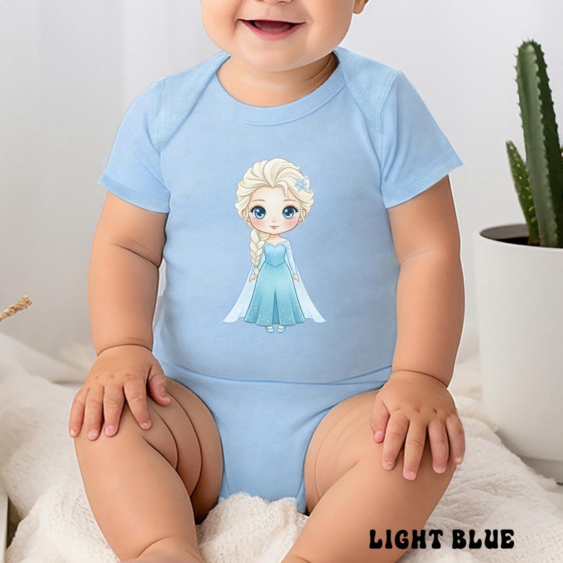 Puede incluir: Body de beb&eacute; azul claro con una ilustraci&oacute;n de dibujos animados de una princesa con un vestido azul. El body tiene mangas cortas y cuello redondo. El texto "LIGHT BLUE" est&aacute; impreso en la parte inferior.