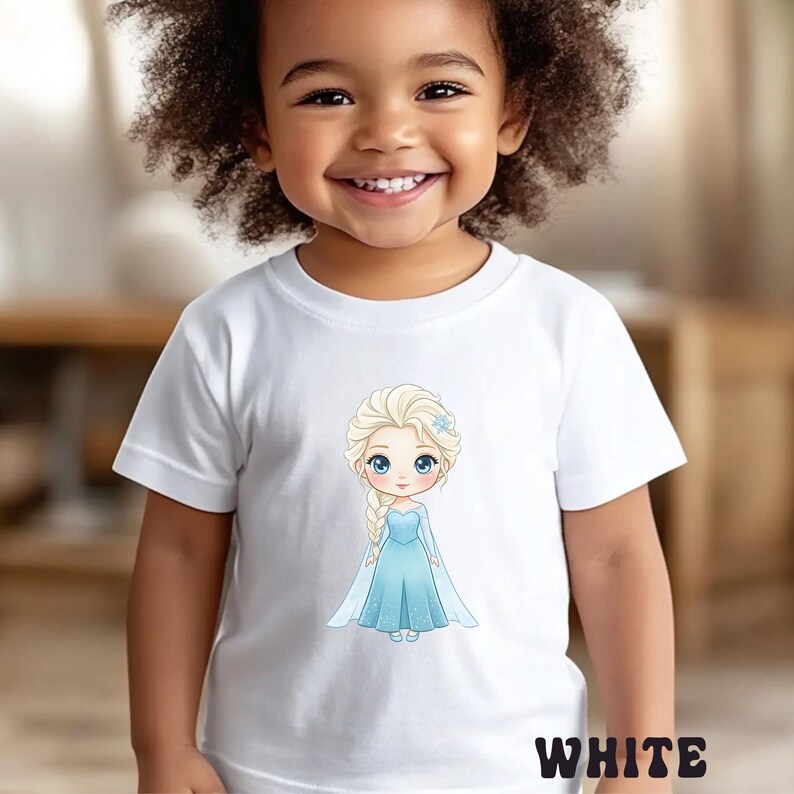 Puede incluir: Camiseta blanca con una ilustraci&oacute;n de dibujos animados de una princesa con un vestido azul y pelo rubio. La palabra "WHITE" est&aacute; impresa en la parte inferior. La camiseta la lleva un ni&ntilde;o peque&ntilde;o.