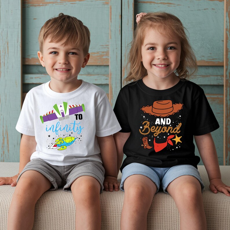 May include: Two children wearing matching t-shirts. One shirt is white with a rocket ship graphic and the words "To Infinity" in blue and purple. The other shirt is black with a cowboy hat and the words "And Beyond".