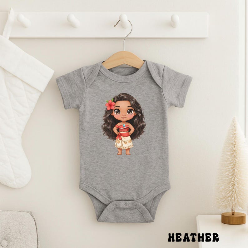 May include: A gray baby bodysuit with a cartoon illustration of a girl with long, dark hair, a red flower, and a red and white outfit. The word "HEATHER" is printed in black at the bottom of the image.