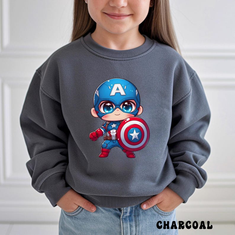 Op de afbeelding: Antracietgrijs sweatshirt met een cartoon Captain America-afbeelding. De illustratie toont Captain America met zijn schild. Het woord "CHARCOAL" staat onderaan de afbeelding.
