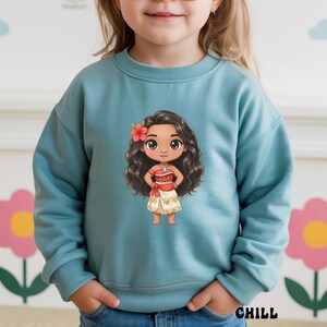 May include: A light blue sweatshirt featuring a cartoon illustration of a character with long, dark curly hair, a red flower, and a red and white outfit. The word "CHILL" is printed in black at the bottom right.