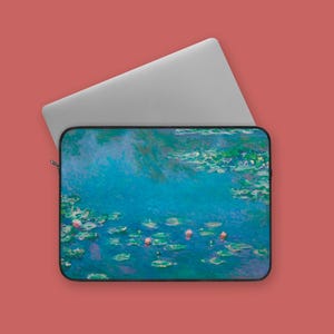 May include: A laptop sleeve displaying an impressionist painting of water lilies in a pond. The artwork features blues, greens, and pinks, with a silver laptop partially visible. The sleeve has a black border and a zip.