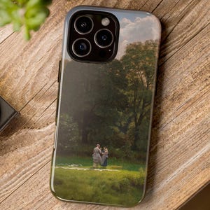 Op de afbeelding: Smartphonehoesje met een landschapsschilderij. De hoes heeft een donkerblauwe rand en een glanzende afwerking. De schildering toont een groen veld, bomen en een bewolkte lucht. Figuren zijn zichtbaar.