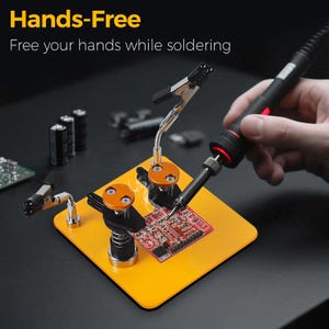 May include: A hands-free soldering station with a bright yellow base, holding a circuit board with adjustable clamps. The text "Hands-Free" and "Free your hands while soldering" are displayed at the top.