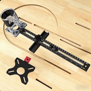 May include: A black and clear router circle jig with inch and millimeter markings. The jig is on a light wood surface with a circular groove cut into it. The jig has a clear plastic base and a black metal arm with measurements up to 38 mm and 15 inches (38.1 cm).