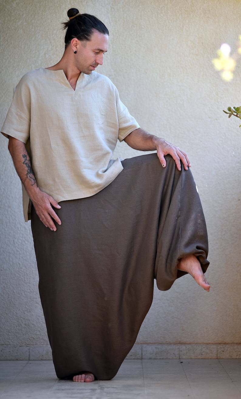 A person wearing a light brown linen top with a v-neck and a brown linen pair of harem pants.