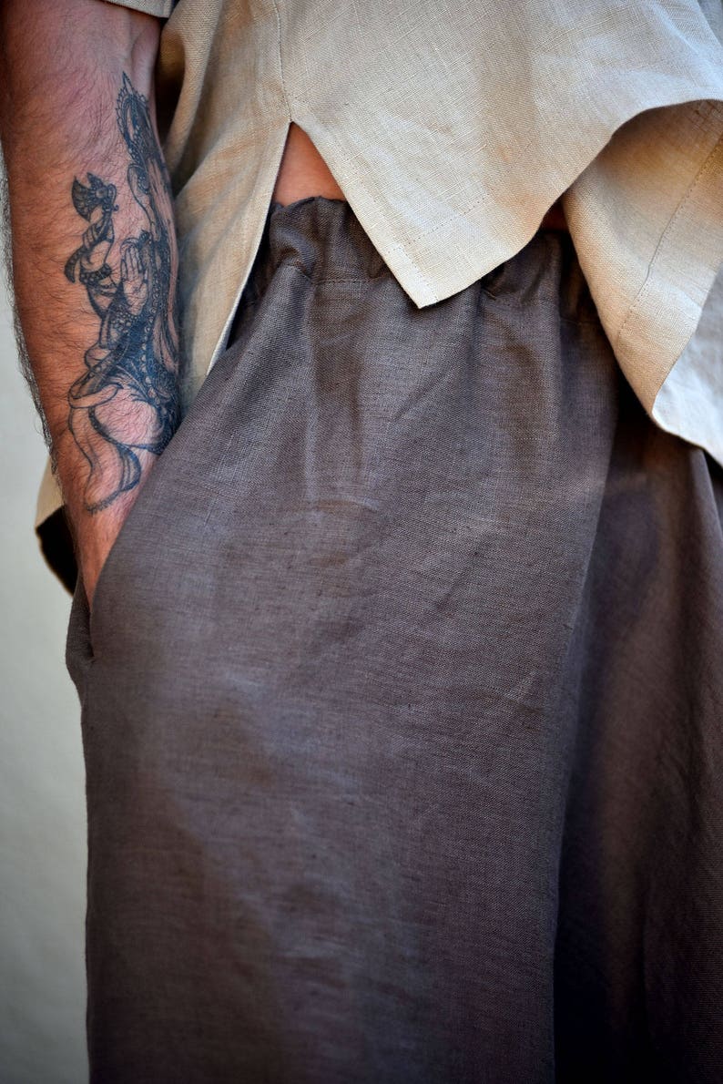 A pair of brown linen trousers with a relaxed fit. The pants have side 
pockets and a wide leg.