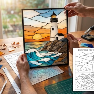Puede incluir: Un panel de vidrieras que representa un faro en una costa rocosa al atardecer con olas azules. El panel tiene un marco negro y se acompaña de una hoja de patrón PDF imprimible con secciones numeradas para el ensamblaje.