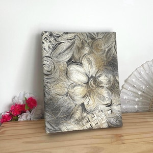 Peut inclure: Une toile rectangulaire ornée d'un motif floral texturé en doré métallique et gris anthracite. Le design présente des fleurs et des feuilles stylisées superposées avec une finition scintillante et vieillie sur toute la surface.