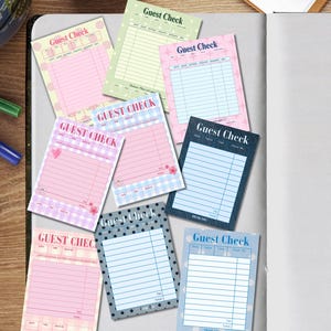 May include: A collection of nine rectangular paper guest check pads featuring various patterns and colors including pink, blue, green, and dark gray. Each pad is printed with the text Guest Check and includes columns for date, table, and items.