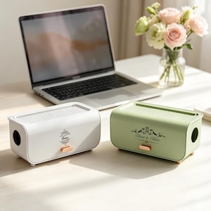 Peut inclure: Deux boîtes de rangement rectangulaires aux coins arrondis, l'une blanche et l'autre vert sauge. Chaque boîte présente un dessus nervuré, une petite poignée en or rose et un emblème décoratif noir avec les noms Grace et Oliver & Chloe.