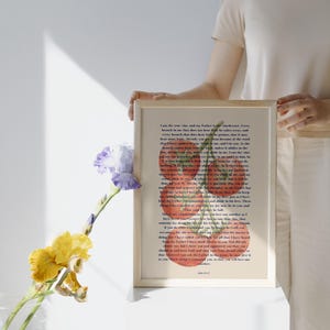 Può includere: Stampa incorniciata con un'illustrazione ad acquerello di pomodori e steli verdi, sovrapposta a testo. La cornice colorata è tenuta da una persona. Un vaso di fiori è in primo piano.