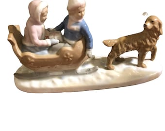 Figurine of boy and girl with dog