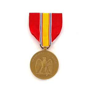May include: A gold National Defense Service Medal with a red, white, and yellow ribbon. The medal features an eagle with wings spread.