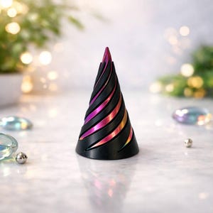 May include: A black, cone-shaped decorative object with spiraling, iridescent stripes of pink, orange, and purple. The object has a pointed top and a wide base. The background is blurred with bokeh lights.