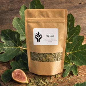 May include: A brown paper pouch containing dried fig leaves, featuring a white label with the text Present Body Co. Fig Leaf, Dried Cut Fruit Leaf, Single Botanical Tea Ingredient. A fresh fig half sits beside the pouch.