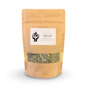 May include: A brown paper bag with a clear window, filled with dried green fig leaves. A white label displays the text "Present Body Co. Fig Leaf" with a logo of hands holding leaves. The bag is sealed and ready for use.