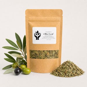 Könnte beinhalten: Ein brauner Kraftpapierbeutel mit getrockneten Olivenblättern und einem Sichtfenster. Das Etikett trägt die Aufschrift Present Body Co. Olive Leaf, Dried Cut Fruit Leaf, Single Botanical Tea Ingredient, Net Wt 1 oz (28g).