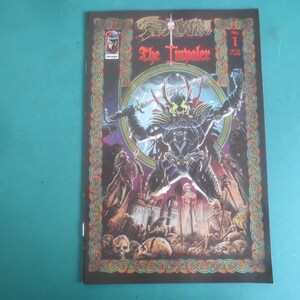 May include: A comic book titled "Spawn: The Impaler" No. 1. The cover features a central figure with a horned helmet, holding a sword, surrounded by skulls and other figures. The background is dark with a decorative border.