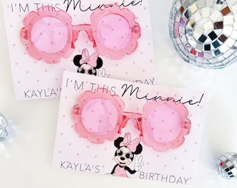 May include: Two pairs of pink flower-shaped sunglasses with polka-dot lenses are displayed on cards. The cards feature the text "I'M THIS Minnie!" and a Minnie Mouse graphic. The cards also say "KAYLA'S BIRTHDAY".