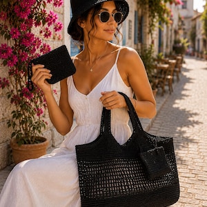 May include: A black crocheted bucket hat, a matching black crocheted tote bag with an open-weave design, and a small black crocheted wristlet pouch. The tote bag features a solid base and a structured handle, while the pouch hangs from the side.