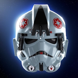 Könnte beinhalten: Detaillierte Frontansicht eines grauen AT-AT-Pilotenhelms. Der Helm hat rote und weiße Embleme auf jeder Seite, schwarze Akzente und ein zentrales Visier. Der Hintergrund ist dunkelblau mit Sterneneffekt.