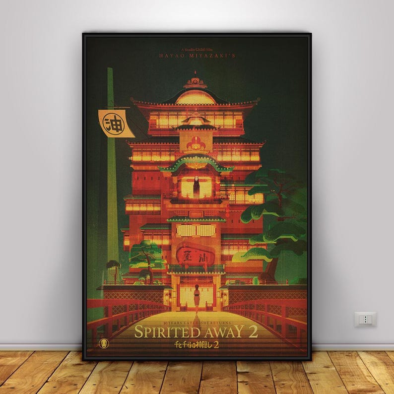 May include: A framed poster featuring a vibrant illustration of a Japanese bathhouse from the animated film "Spirited Away." The artwork showcases a multi-story building with red and orange hues, a bridge, and Japanese text. The poster is set against a dark background.