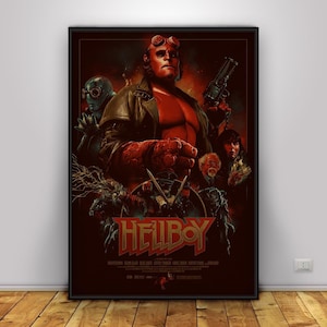 May include: A framed movie poster for the film "Hellboy." The poster features a central image of the titular character, a red-skinned demon, holding a gun. Other characters and the film's title are also displayed in a dark, dramatic style.