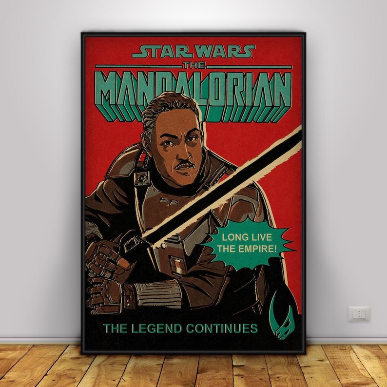 May include: A framed poster for Star Wars: The Mandalorian. The image shows a man with a moustache, holding a lightsaber. Text includes "STAR WARS THE MANDALORIAN" and "LONG LIVE THE EMPIRE!" in a retro style.