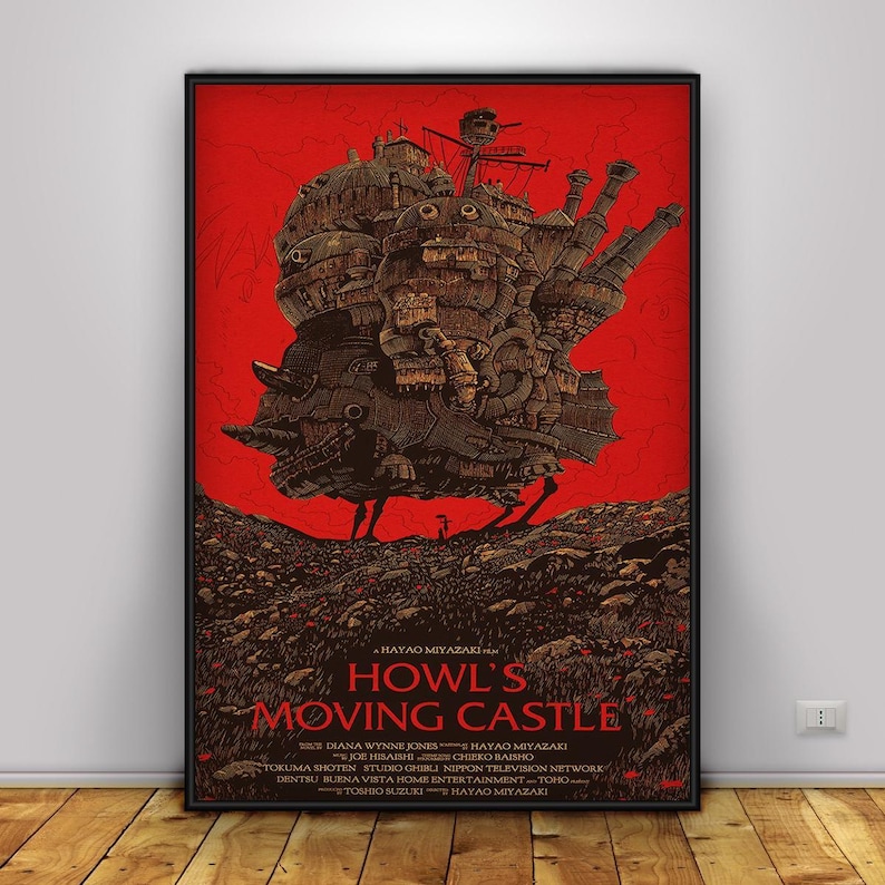 K&ouml;nnte beinhalten: Gerahmtes Poster des Animationsfilms "Das wandelnde Schloss". Das Kunstwerk zeigt das Schloss in Braun- und Beiget&ouml;nen vor rotem Hintergrund. Titel und Credits sind in braunem Text unten dargestellt.