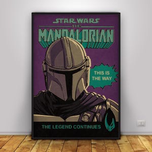 May include: A framed poster featuring The Mandalorian from Star Wars. The poster has a purple background with the title in teal and the Mandalorian's helmet in the centre. Text includes "This is the Way" and "The Legend Continues."