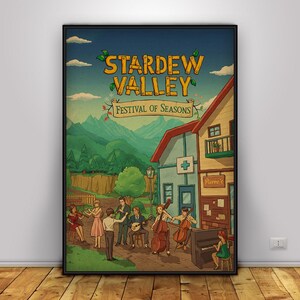 May include: A framed poster featuring the text "Stardew Valley Festival of Seasons." The artwork depicts a town scene with musicians playing instruments in front of buildings and mountains. The color palette includes blues, greens, and browns.