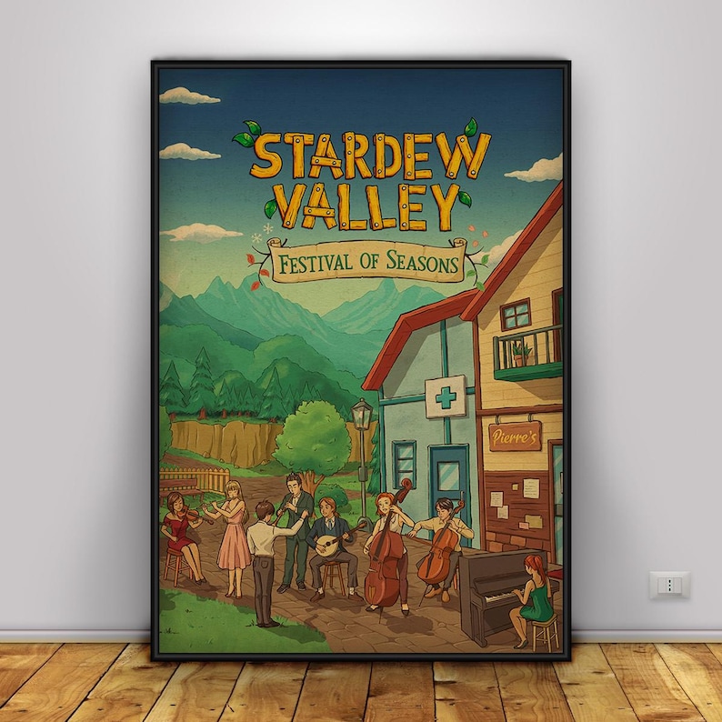 May include: A framed poster featuring the text "Stardew Valley Festival of Seasons." The artwork depicts a town scene with musicians playing instruments in front of buildings and mountains. The color palette includes blues, greens, and browns.