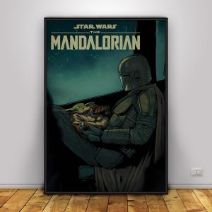 May include: A framed poster featuring artwork from the Star Wars series, The Mandalorian. The image shows the Mandalorian in his armour, holding Grogu. The poster has the words "STAR WARS THE MANDALORIAN" at the top.
