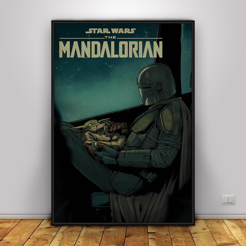 May include: A framed poster featuring artwork from the Star Wars series, The Mandalorian. The image shows the Mandalorian in his armour, holding Grogu. The poster has the words "STAR WARS THE MANDALORIAN" at the top.