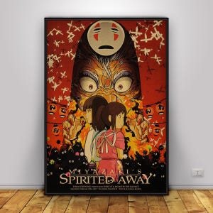 Op de afbeelding: Een ingelijste poster van de animatiefilm "Spirited Away." De afbeelding toont personages en beelden uit de film, met een rood en oranje kleurenschema. De poster bevat Japanse tekst en de titel van de film.