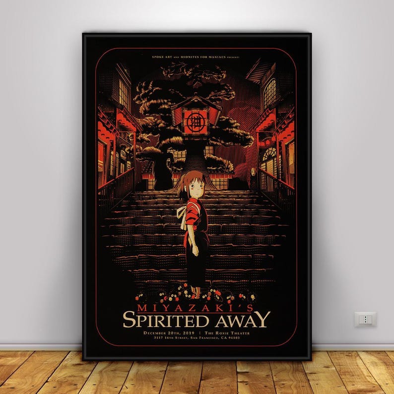 Op de afbeelding: Een ingelijste poster met een sc&egrave;ne uit Miyazaki's Spirited Away. Het kunstwerk toont een jong meisje op een trap, met een gebouw in Japanse stijl op de achtergrond. Het kleurenpalet is voornamelijk rood en zwart, met de titeltekst onderaan.
