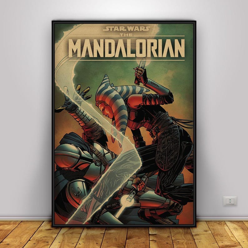 May include: A framed poster with a Star Wars: The Mandalorian comic-style illustration. The artwork shows two figures in combat, one with a lightsaber. The poster has a vintage aesthetic with a green and brown colour scheme.