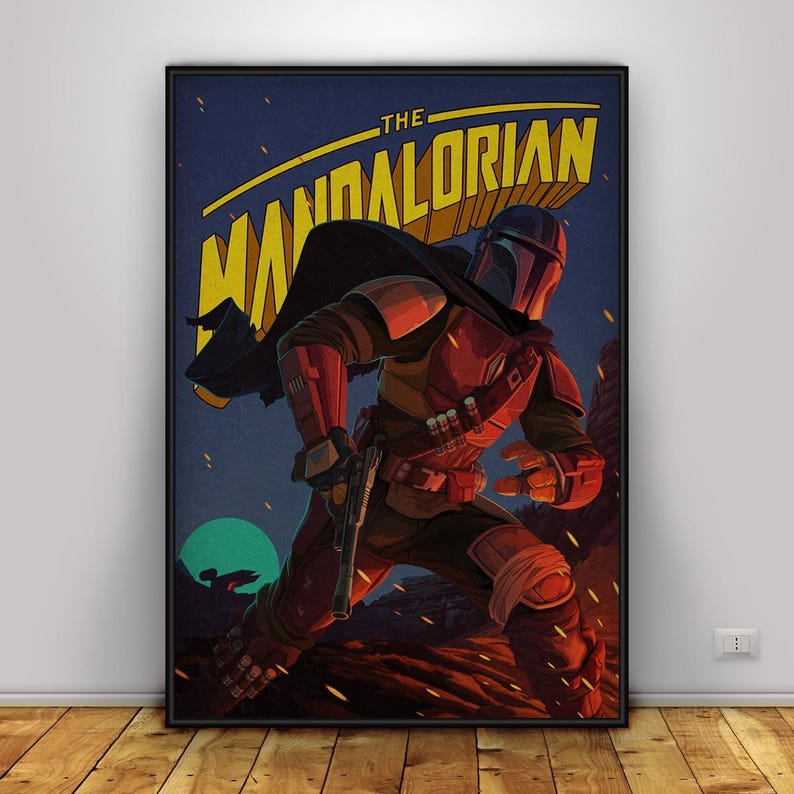 May include: A framed poster featuring The Mandalorian. The artwork shows the Mandalorian in a dynamic pose, running across a rocky landscape. The poster has a dark blue background with yellow text and a green moon.