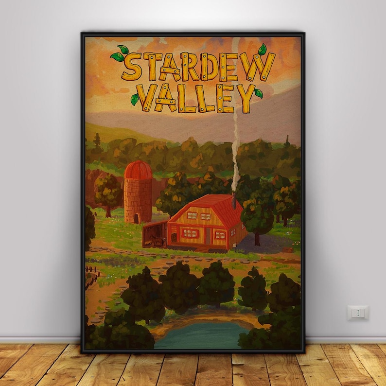 May include: A framed poster featuring a rural landscape with a red-roofed house, silo, and pond. The words "Stardew Valley" are at the top in a wooden-style font. The artwork has a warm, inviting color palette.