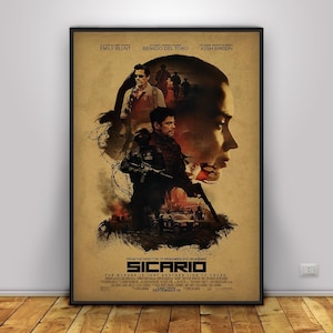 Könnte beinhalten: Gerahmtes Filmplakat für "Sicario" mit Emily Blunt, Benicio Del Toro und Josh Brolin. Das Poster hat einen Sepia-Ton mit Bildern der Schauspieler und dem Text "SICARIO" und "September 18".