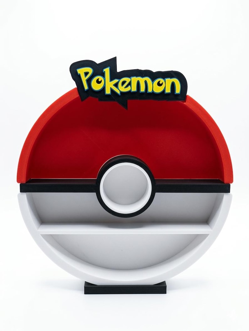 May include: A red, white, and black Pokemon-themed shelf unit. The top features the word "Pokemon" in yellow and black. The shelf has a circular design with two shelves and a white circle in the middle.