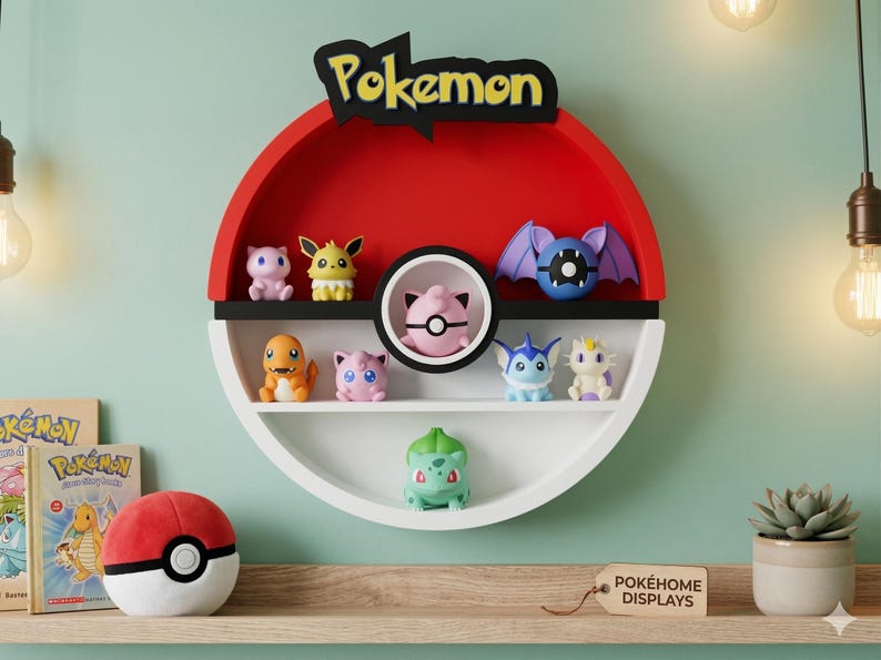 May include: A red, white, and black Pokemon-themed shelf shaped like a Poke Ball, displaying various Pokemon figurines. The shelf has a black "Pokemon" logo and is mounted on a light green wall. A Poke Ball plush and books are on a wooden shelf below.